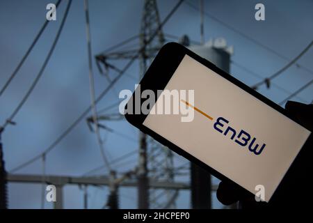 Rheinbach, Deutschland 5. Oktober 2021, das Markenlogo des Energieversorgers EnBW auf dem Display eines Smartphones vor einer Transformationsstation Stockfoto