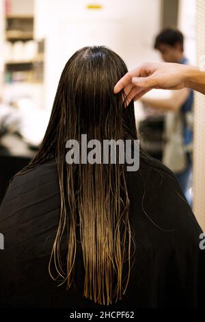 Frau auf dem Rücken im Friseursalon mit nassem Haar Stockfoto