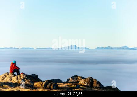 Eine Person, die vom Gipfel des Ben Cleuch in den Ochil Hills, Schottland, über ein Wolkenmeer blickt Stockfoto