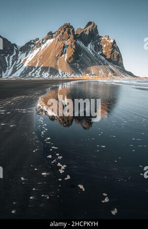 Luftdrohnenansicht des Sonnenuntergangs Runrise und wunderschöne Reflexion des Vestrahorn Berg auf Stokksnes Kap in Island. Wunderschöne schneebedeckte Berge Stockfoto