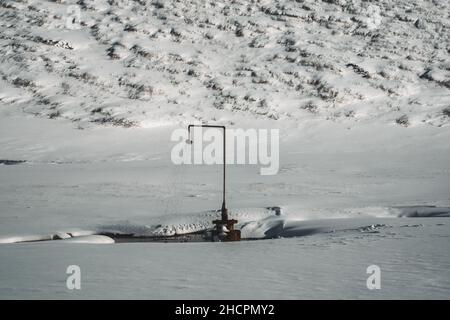 Ein Duschkopf, der in eine heiße Quelle in Island gezapft wird, spritzt das ganze Jahr über heißes Wasser aus. Natürlich braucht jede Dusche eine Toilette, um sie zu begleiten. Das ist es Stockfoto