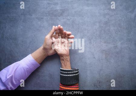 Detail Aufnahme eines jungen Mannes, der die Hand eines älteren Mannes hält Frauen Stockfoto