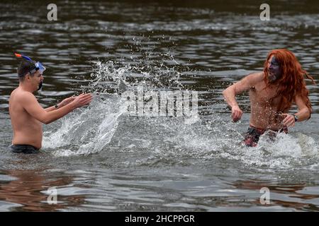 Mlada Boleslav, Tschechische Republik. 31st Dez 2021. Menschen, die während der Taufe in Mlada Boleslav in der Nähe der Fabrik Skoda Auto in der Tschechischen Republik im eiskalten Wasser des Flusses Jizera schwimmen. Begeisterte Schwimmer trotzen jedes Jahr dem kalten Wasser zum Schwimmen und Taufe neue Schwimmer. (Bild: © Slavek Ruta/ZUMA Press Wire) Stockfoto