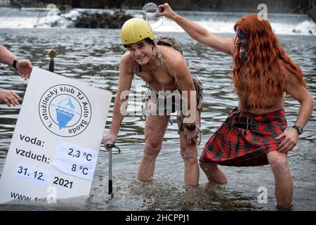 Mlada Boleslav, Tschechische Republik. 31st Dez 2021. Menschen, die während der Taufe in Mlada Boleslav in der Nähe der Fabrik Skoda Auto in der Tschechischen Republik im eiskalten Wasser des Flusses Jizera schwimmen. Begeisterte Schwimmer trotzen jedes Jahr dem kalten Wasser zum Schwimmen und Taufe neue Schwimmer. (Bild: © Slavek Ruta/ZUMA Press Wire) Stockfoto