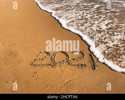 Die Inschrift 2021 auf dem goldenen Sand am Strand. Stockfoto