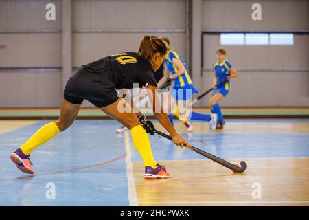 Junge Hockeyspielerin spielt Hallenhockey Stockfoto