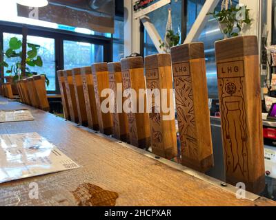 Eine Reihe von hölzernen Bierpumpengriffen zum Abfüllen von Ale im „Left Handed Giant“ Brew Pub in Bristol.UK Stockfoto