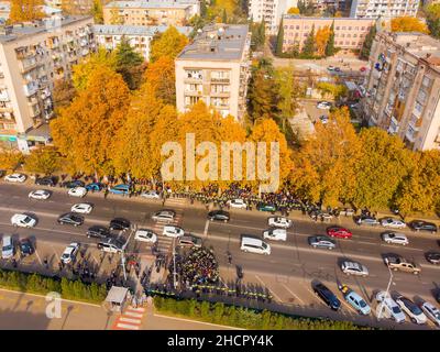 Tiflis, Georgien - 10th. november, 2021: Von oben nach unten aus der Luft Polizeibeamte umgeben eine Menge aggressiver Demonstranten auf der Straße in öffentlichen Anti-Gouvernanten Stockfoto