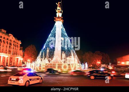 Tiflis, Georgien - 12th. dezember, 2021: Polizei Patrouille Fahrzeug stehen in der Straße am Kreisverkehr und vorbei Autos am Kreisverkehr passieren in Freiheit Platz auf C Stockfoto