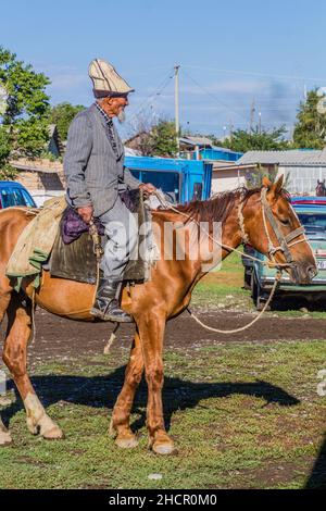 KARAKOL, KIRGISISTAN - 15. JULI 2018: Einheimischer reitet auf dem Sonntagsmarkt in Karakol. Stockfoto