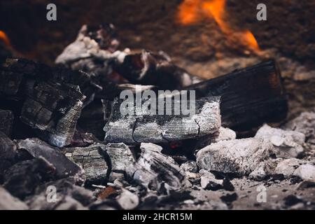 Schwelende Glut und Asche in einem Lagerfeuer. Nahaufnahme. Stockfoto