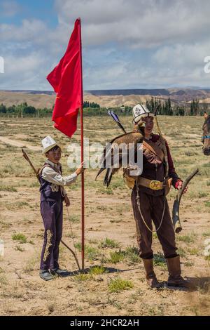 ISSYK KUL, KIRGISISTAN - 15. JULI 2018: Einheimische Jäger mit ihrem Adler beim Ethnofestival Teskey Jeek an der Küste des Issyk-Kul-Sees in Kirgisistan Stockfoto