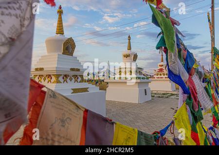 Stupas und Flaggen in der Nähe von Syakusn Syume, Geden Sheddup Choikorling Kloster, tibetisch-buddhistisches Kloster in Elista, Republik Kalmückien, Russland Stockfoto