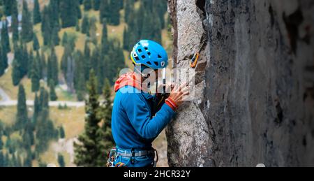 Mann mit Kletterausrüstung klettert Stockfoto