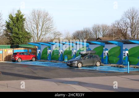 Zwei Autos parkten in einer elektrischen Ladebucht von 150kw in der Wrightington Garage Lancashire UK Stockfoto