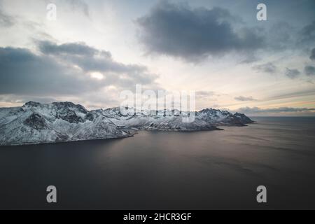 Schaurige Aussicht vom Berg Segla auf das Dorf Fjordgard und den See um ihn herum. Felsige Berge auf der Halbinsel Senja in Nordnorwegen. Arktische w Stockfoto