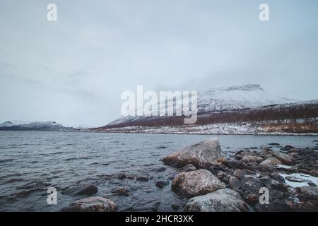 Frostiger Morgen am Lake Ylinen Kilpisjarvi mit Blick auf den Saana-Berg, der im nordwestfinnischen Dorf Kilpisj in einen weißen Nebel getaucht ist Stockfoto