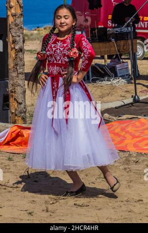 ISSYK KUL, KIRGISISTAN - 15. JULI 2018: Mädchen in traditioneller Kleidung beim Ethnofestival Teskey Jeek an der Küste des Issyk-Kul-Sees in Kirgisistan Stockfoto