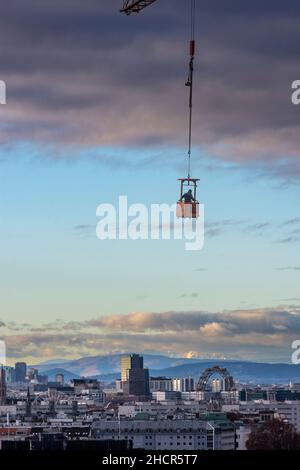 Wien, Wien: Wiener Innenstadt, Riesenrad, Prater, schneebedeckter Schneeberg, Bauarbeiter in Gondel am Kran hängend, 00. Vorbei Stockfoto