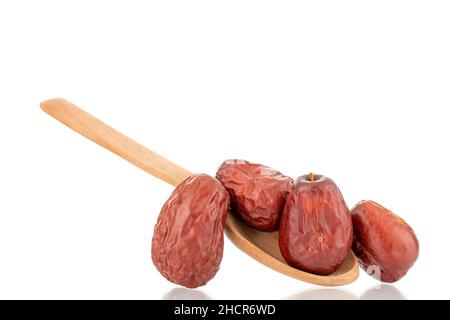 Mehrere süße getrocknete ziziphus-Beeren mit einem Holzlöffel, Nahaufnahme, isoliert auf weiß. Stockfoto