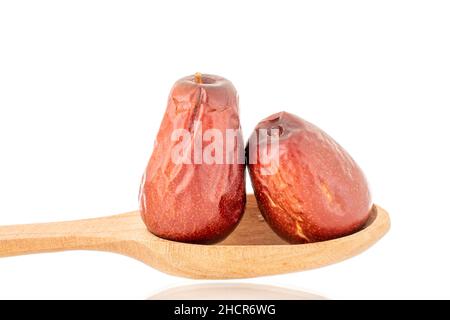 Zwei süße getrocknete ziziphus-Beeren mit einem Holzlöffel, Nahaufnahme, isoliert auf Weiß. Stockfoto