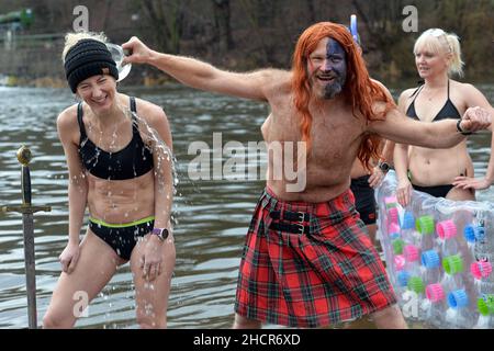 Mlada Boleslav, Tschechische Republik. 31st Dez 2021. Menschen, die während der Taufe in Mlada Boleslav in der Nähe der Fabrik Skoda Auto in der Tschechischen Republik im eiskalten Wasser des Flusses Jizera schwimmen. Begeisterte Schwimmer trotzen jedes Jahr dem kalten Wasser zum Schwimmen und Taufe neue Schwimmer. (Bild: © Slavek Ruta/ZUMA Press Wire) Stockfoto