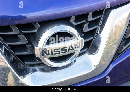 Nahaufnahme des verchromten Nissan-Grill-Emblems auf dem Kühlergrill Stockfoto