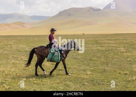 SONG KUL, KIRGISISTAN - 24. JULI 2018: Örtlicher Reiter in der Nähe des Song Kul Sees, Kirgisistan Stockfoto