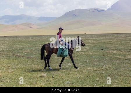 SONG KUL, KIRGISISTAN - 24. JULI 2018: Örtlicher Reiter in der Nähe des Song Kul Sees, Kirgisistan Stockfoto