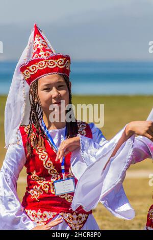 SONG KOL, KIRGISISTAN - 25. JULI 2018: Traditionelles Kleid trägt Mädchen während der National Horse Games Festival am Ufer des Son Kol See Stockfoto