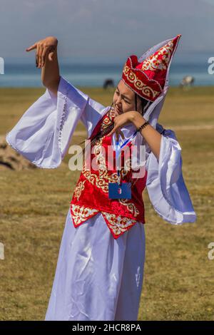 SONG KOL, KIRGISISTAN - 25. JULI 2018: Traditionelles Kleid trägt Mädchen während der National Horse Games Festival am Ufer des Son Kol See Stockfoto