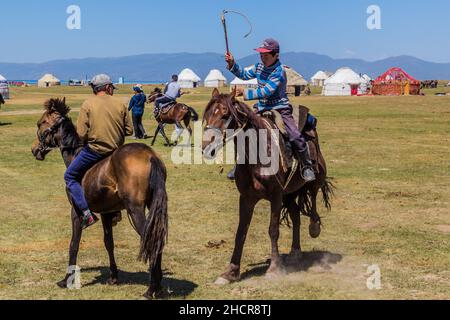 SONG KOL, KIRGISISTAN - 25. JULI 2018: Jungs auf Pferden beim National Horse Games Festival am Ufer des Son Kol Sees Stockfoto