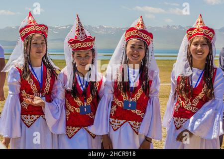 SONG KOL, KIRGISISTAN - 25. JULI 2018: Traditionelle Kleidung mit Mädchen während des National Horse Games Festivals am Ufer des Son Kol Sees Stockfoto