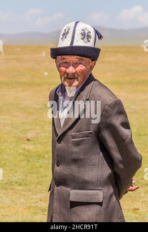 SONG KOL, KIRGISISTAN - 25. JULI 2018: Traditionelle Kleidung mit einem älteren Mann während des National Horse Games Festivals am Ufer des Son Kol Sees Stockfoto