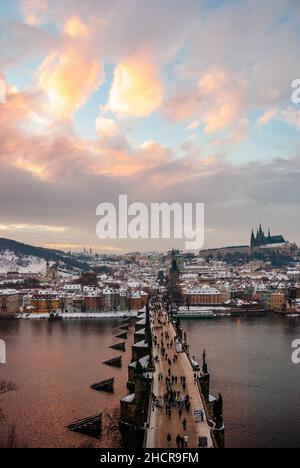 Europa, Tschechische Republik, Prag. Karlsbrücke & Moldau bei Sonnenuntergang nach einem Schneefall. Prager Burg & St. Veits Kathedrale in der Ferne. Stockfoto