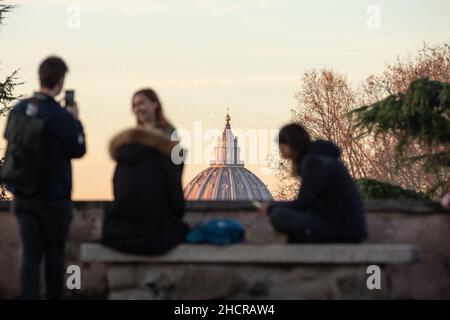 Rom, Italien. 31st Dez 2021. Touristen beobachten den Petersdom am 31. Dezember 2021 von der Piazzale Garibaldi auf dem Gianicolo-Hügel bei Sonnenuntergang (Bild: © Matteo Nardone/Pacific Press via ZUMA Press Wire) Quelle: ZUMA Press, Inc./Alamy Live News Stockfoto