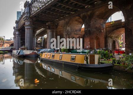 Großbritannien, England, Manchester, Castlefield, Bridgewater Canal Basin, Residential Kanal Schmalboot unter redundanten Eisenbahn Viadukt Stockfoto