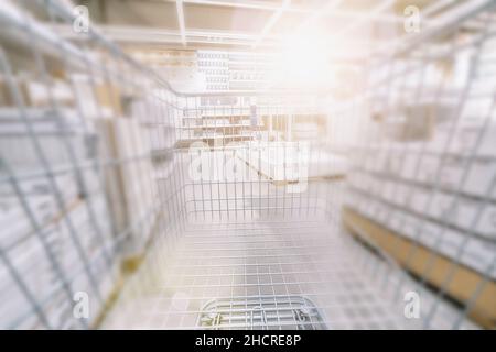 Verschwommener Supermarkt mit leerem Warenkorb Stockfoto
