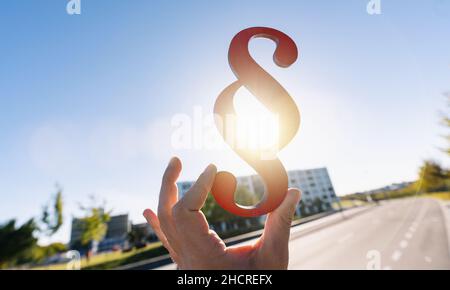 Hand hält Absatz Zeichen in der Sonne als Symbol für die Idee des Gesetzes Stockfoto