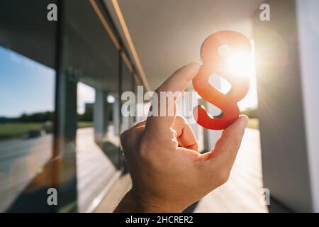 Hand hält Absatz in der Sonne als Zeichen von Gerechtigkeit und Gesetz Stockfoto