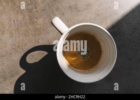 Tasse Kaffee auf grauem Hintergrund, Ansicht von oben Stockfoto