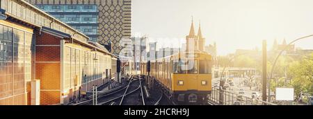 Panoramablick auf die Berliner U-Bahn mit der oberbaum Bridge im Hintergrund im goldenen Abendlicht bei Sonnenuntergang mit Retro Vintage Instagram Style Hüfthose Stockfoto