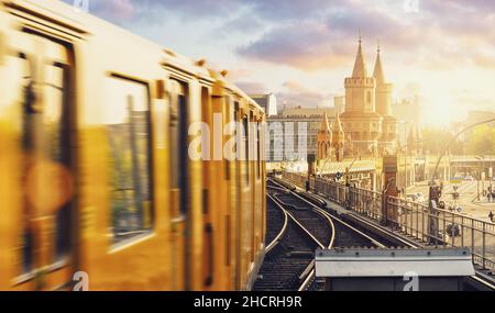 Panoramablick auf die Berliner U-Bahn mit Oberbaumbrücke im Hintergrund im goldenen Abendlicht bei Sonnenuntergang mit dramatischen Wolken, Berlin Friedrichshain Stockfoto