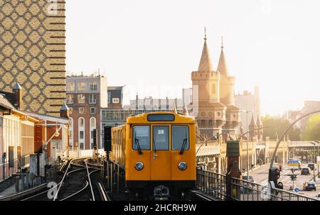 Berliner U-Bahn mit Oberbaumbrücke im Hintergrund in goldenem Abendlicht bei Sonnenuntergang, Hauptstadt von Deutschland Stockfoto