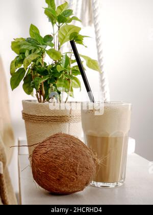 Coconut Latte in einem hohen Glas und Coconut auf einer Schaukel in einem Café. Nahaufnahme. Stockfoto