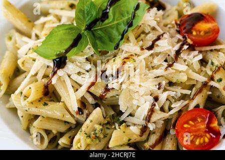 Pasta mit Gemüse, Parmesan und cremiger Sauce in einer Schüssel auf dem Tischhintergrund. Draufsicht Stockfoto