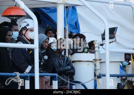 Sizilien, Italien. 31st Dez 2021. Die letzten Migranten kommen am letzten Tag des Jahres nach Sizilien. Die Seeretter der „Sea-Watch 3“ mit 440 Personen an Bord mussten 8 Tage warten, bis sie einen sicheren Hafen zugewiesen bekommen. Jetzt dürfen sie in die sizilianische Stadt Pozzallo einreisen.an Bord waren mehr als 200 Kinder, 167 davon ohne Eltern oder Begleiter. Sie alle gingen in kleinen Booten in Libyen auf See. Viele von ihnen kommen aus Ländern südlich der Sahara. Quelle: Alessio Tricani/Alamy Live News Stockfoto