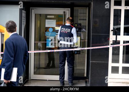 Vendrell, Spanien. 31st Dez 2021. Ein Agent der katalanischen Polizei wacht am Ort des Diebstahls über den Eingang des Büros der CaixaBank ein Mann mit einem Messer führt einen Raub in einem Büro der Bank CaixaBank in El Vendrell (Tarragona, Spanien) durch Flucht mit einer Sammlung, die noch von den Bankverantwortlichen bestimmt werden muss. Die katalanische Polizei untersucht den Ort des Raubes und sucht nach Fingerabdrücken des Räubers. Kredit: SOPA Images Limited/Alamy Live Nachrichten Stockfoto