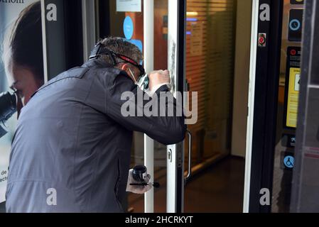 Vendrell, Spanien. 31st Dez 2021. Ein Agent der Diebstahluntersuchungsgruppe der katalanischen Polizei sucht an der Eingangstür des Bankbüros der CaixaBank nach den Fingerabdrücken des Räubers ein Mann mit einem Messer führt in einem Büro der Bank CaixaBank in El Vendrell (Tarragona, Spanien) einen Raub durch Flucht mit einer Sammlung, die noch von den Bankverantwortlichen bestimmt werden muss. Die katalanische Polizei untersucht den Ort des Raubüberfalls und sucht nach Fingerabdrücken des Räubers Credit: SOPA Images Limited/Alamy Live News Stockfoto