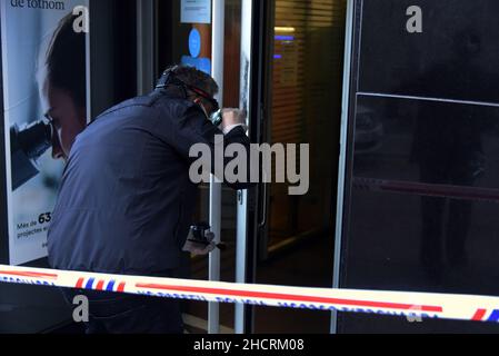 Vendrell, Spanien. 31st Dez 2021. Ein Agent der katalanischen Polizei-Diebstahluntersuchungsgruppe sucht an der Eingangstür des Bankbüros der CaixaBank nach den Fingerabdrücken des Räubers ein Mann mit einem Messer führt einen Raub in einem Büro der Bank CaixaBank in El Vendrell (Tarragona, Spanien) durch. Flucht mit einer Sammlung, die noch von den Bankverantwortlichen bestimmt werden muss. Die katalanische Polizei untersucht den Ort des Raubüberfalls und sucht nach Fingerabdrücken des Räubers Credit: SOPA Images Limited/Alamy Live News Stockfoto